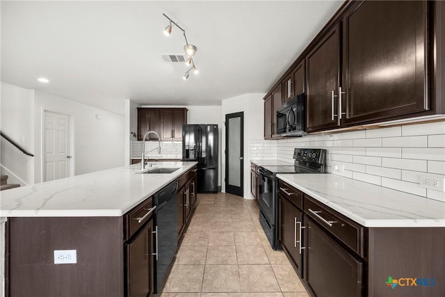 306 W Gemini Ln, Killeen, TX 76542 - kitchen featuring black appliances, tasteful backsplash, dark brown cabinets, light tile patterned floors, and a center island with sink