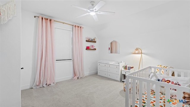 carpeted bedroom featuring ceiling fan, a nursery area, and lofted ceiling