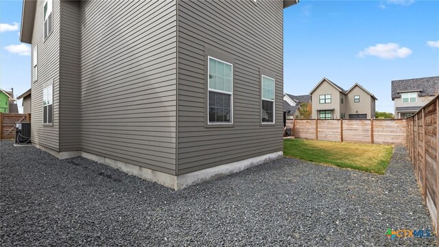 view of property exterior with a lawn and central AC unit