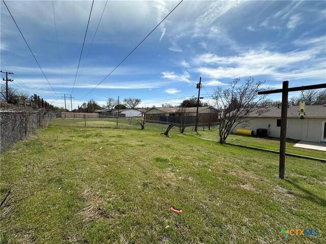 view of yard featuring central air condition unit and fence