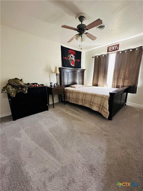 bedroom with carpet flooring, ceiling fan, baseboards, and visible vents