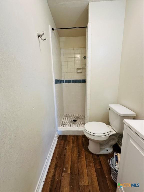 full bath featuring a shower stall, toilet, vanity, and hardwood / wood-style floors