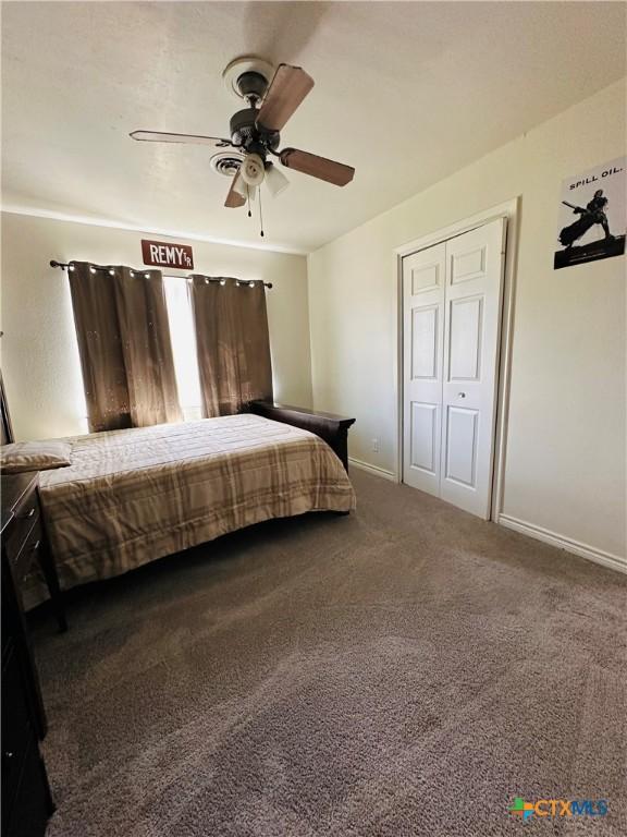 carpeted bedroom featuring a ceiling fan and baseboards