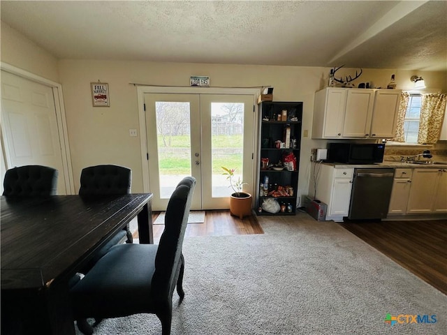 dining area featuring french doors, a textured ceiling, and dark wood-style flooring
