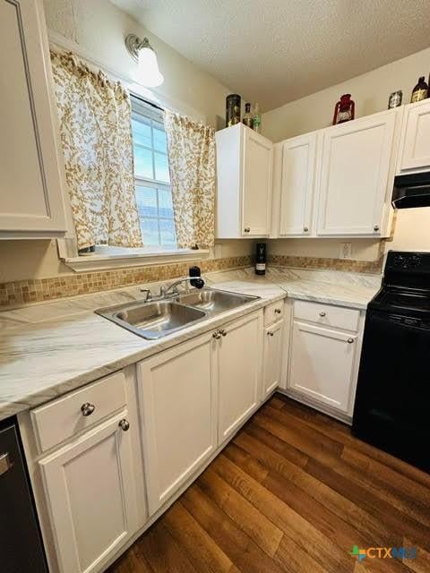 kitchen with black appliances, a sink, a textured ceiling, white cabinetry, and light countertops