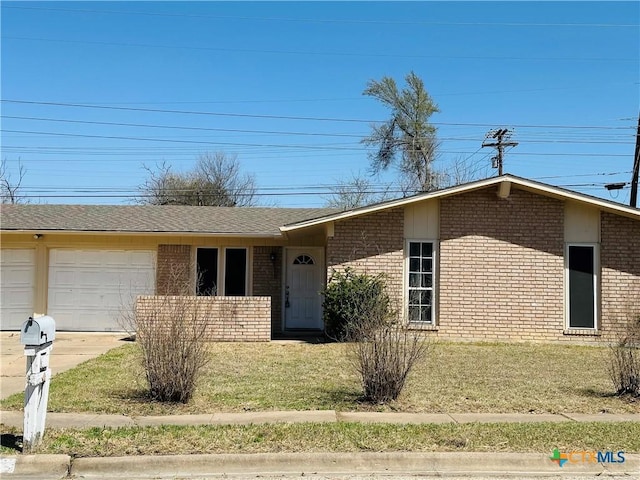 view of front of home with concrete driveway, a garage, brick siding, and a front yard