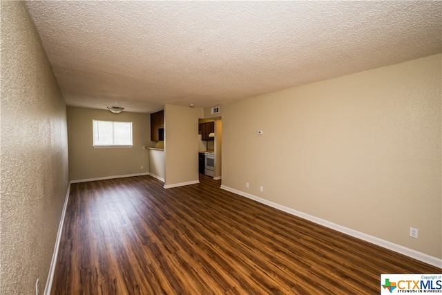 empty room with dark wood-type flooring and a textured ceiling