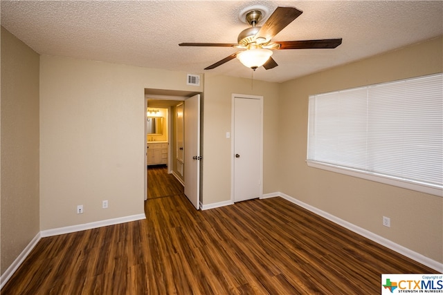 unfurnished bedroom with ceiling fan, a textured ceiling, and dark hardwood / wood-style flooring