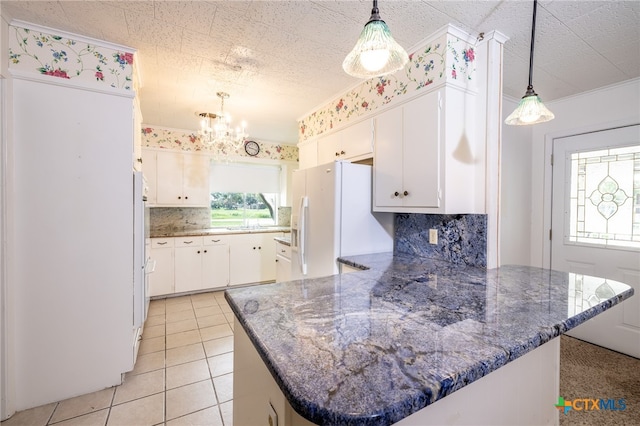 kitchen featuring decorative backsplash, white fridge with ice dispenser, and white cabinets