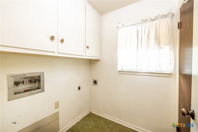 laundry area with hookup for an electric dryer, hookup for a washing machine, and cabinets