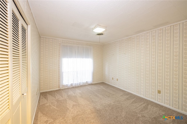 unfurnished bedroom featuring carpet flooring and a textured ceiling