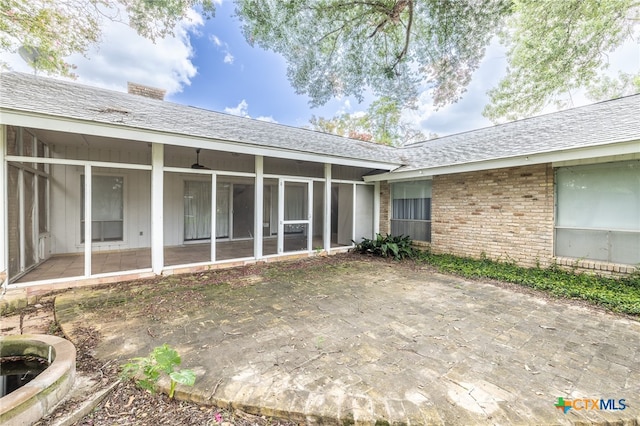 rear view of house featuring a sunroom and a patio