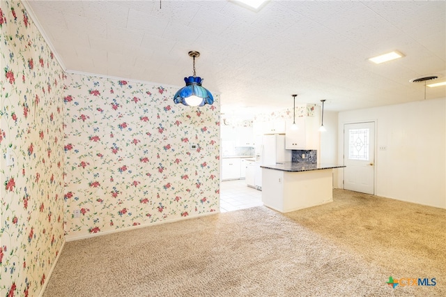 kitchen with a center island, light colored carpet, white cabinetry, and hanging light fixtures