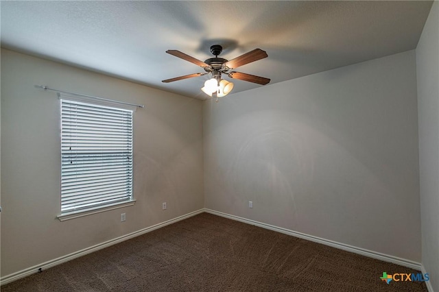 unfurnished room featuring baseboards, ceiling fan, and dark carpet