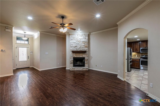 unfurnished living room with ornamental molding, visible vents, a ceiling fan, and wood finished floors