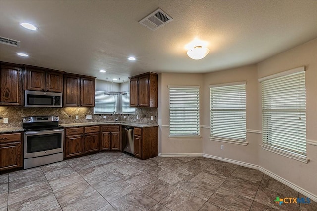 kitchen featuring a sink, visible vents, tasteful backsplash, and appliances with stainless steel finishes