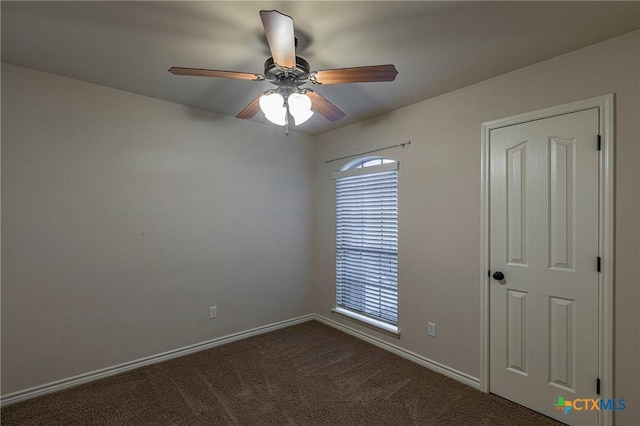 unfurnished room featuring baseboards, ceiling fan, and dark carpet