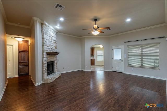 unfurnished living room featuring visible vents, crown molding, wood finished floors, a ceiling fan, and arched walkways