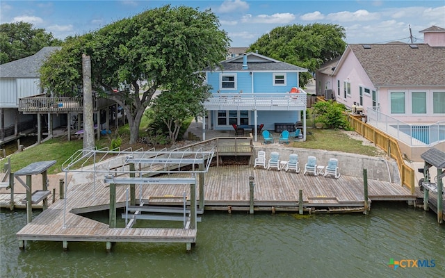 dock area with cooling unit, a lawn, and a water view