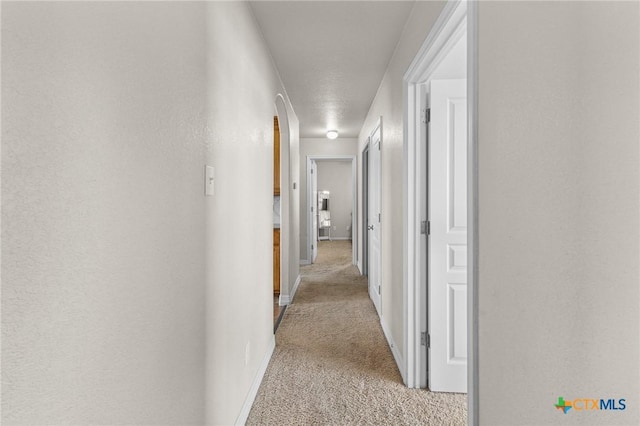 820 Thomas St, Copperas Cove, TX 76522 - hallway featuring light carpet, baseboards, and arched walkways