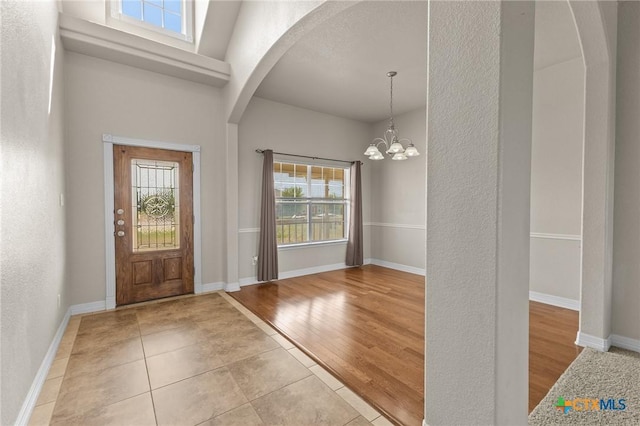 820 Thomas St, Copperas Cove, TX 76522 - foyer with arched walkways, a chandelier, wood finished floors, a textured wall, and baseboards