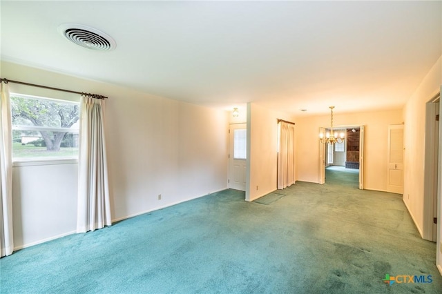 carpeted empty room featuring a notable chandelier, visible vents, and baseboards