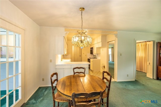 carpeted dining room featuring baseboards, an inviting chandelier, and a sink
