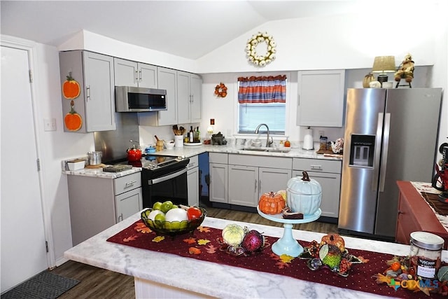 kitchen featuring gray cabinetry, appliances with stainless steel finishes, lofted ceiling, and sink