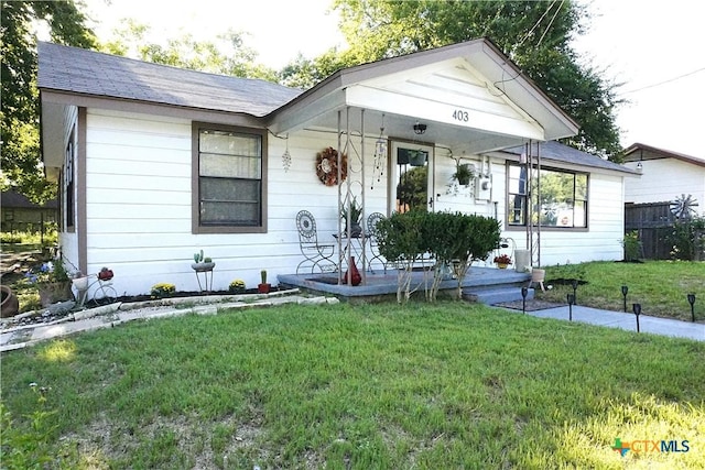 view of front of home featuring covered porch and a front lawn