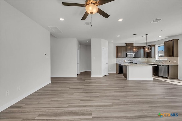 unfurnished living room with ceiling fan and light hardwood / wood-style floors