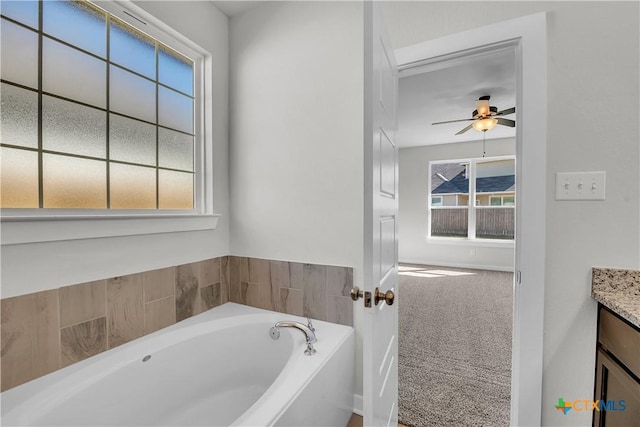 bathroom with vanity, a bath, and ceiling fan