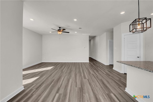 unfurnished living room featuring ceiling fan and wood-type flooring