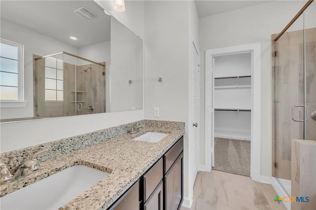 bathroom with a shower with door and vanity