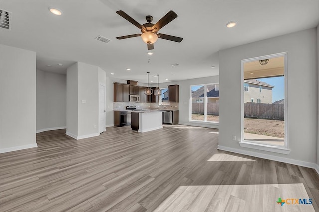 unfurnished living room featuring ceiling fan and light wood-type flooring