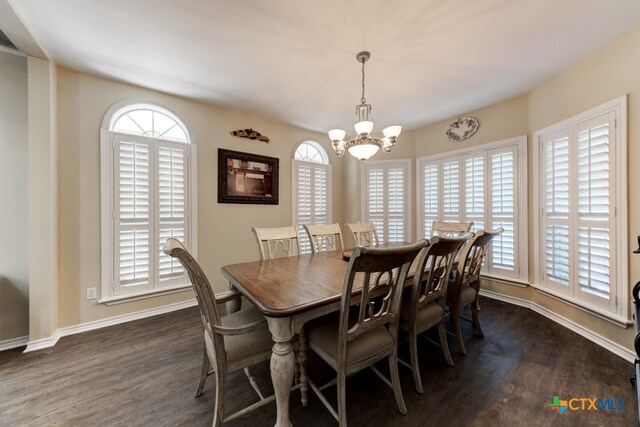 dining space featuring dark wood-type flooring and a chandelier