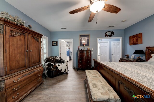 bedroom featuring dark hardwood / wood-style flooring, ceiling fan, a spacious closet, and a closet