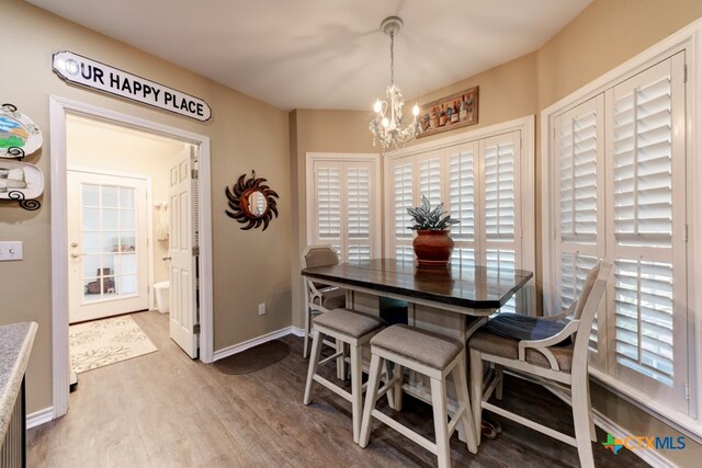 dining area featuring hardwood / wood-style floors and an inviting chandelier