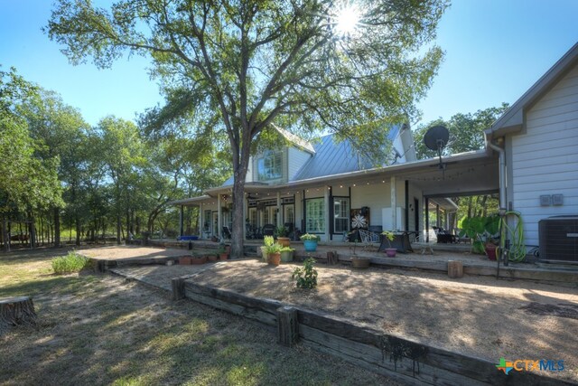 rear view of property with covered porch and cooling unit