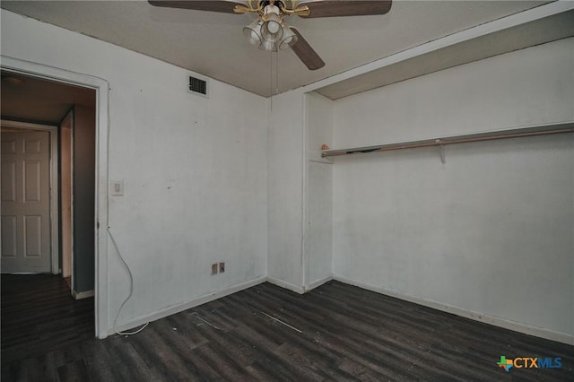 empty room featuring baseboards, visible vents, ceiling fan, and dark wood-style flooring