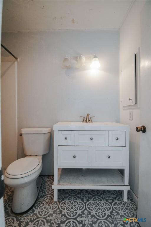 full bath with toilet, vanity, and tile patterned floors