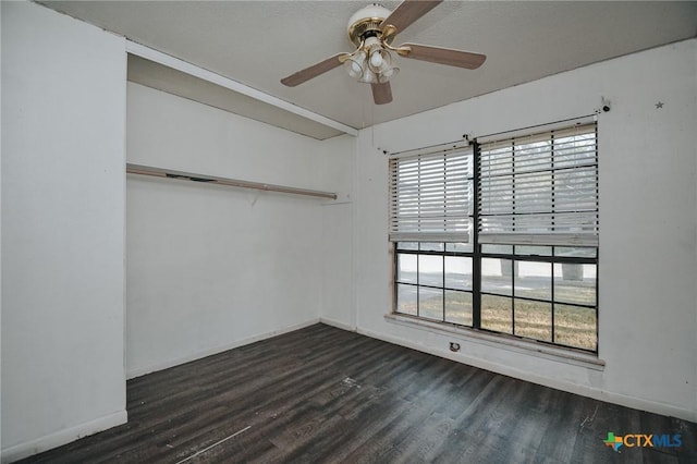 unfurnished room with ceiling fan, dark wood-type flooring, and baseboards