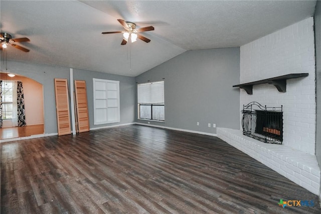 unfurnished living room featuring ceiling fan, a fireplace, wood finished floors, and lofted ceiling