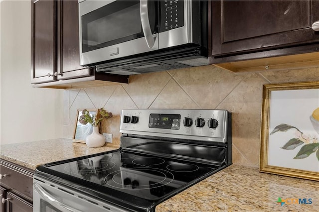 5928 Alexandria Dr, Temple, TX 76502 - kitchen with appliances with stainless steel finishes, dark brown cabinetry, backsplash, and light stone countertops
