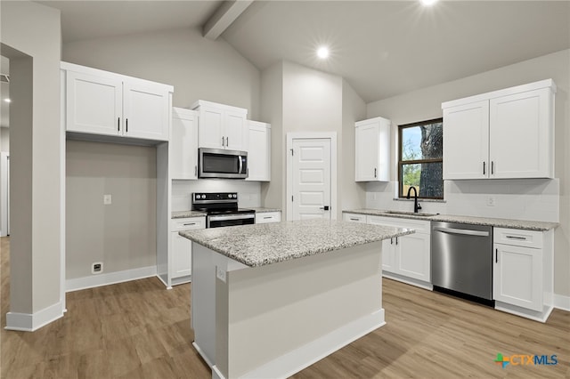 kitchen with white cabinets, a center island, light wood-type flooring, and stainless steel appliances