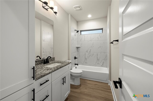 full bathroom featuring vanity, toilet, wood-type flooring, and tiled shower / bath