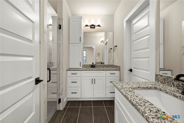 bathroom with tile patterned flooring, vanity, and a shower with door