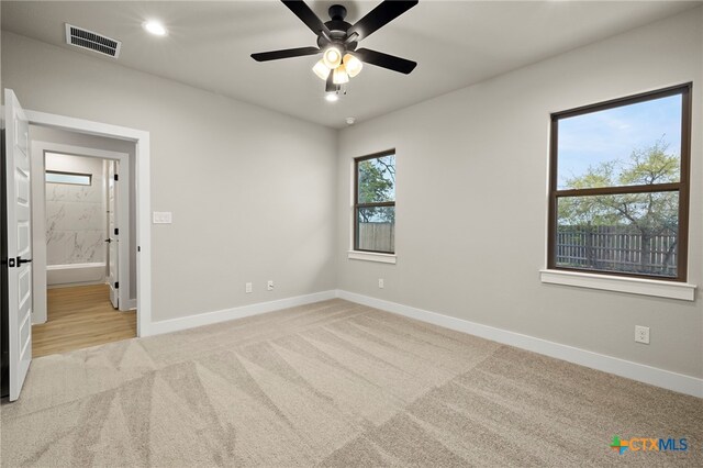 unfurnished room featuring ceiling fan and light carpet