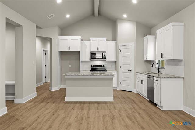 kitchen featuring a center island, white cabinets, appliances with stainless steel finishes, light hardwood / wood-style floors, and light stone counters