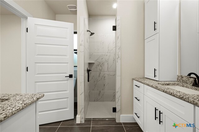 bathroom featuring tile patterned floors, vanity, and a shower with shower door