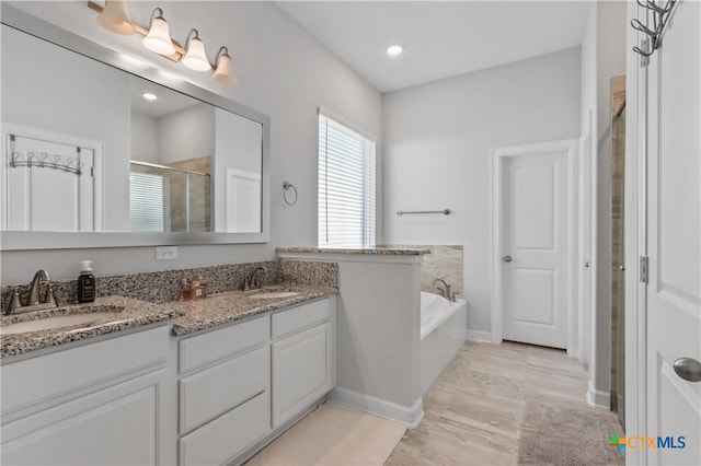 bathroom with independent shower and bath, vanity, and wood-type flooring